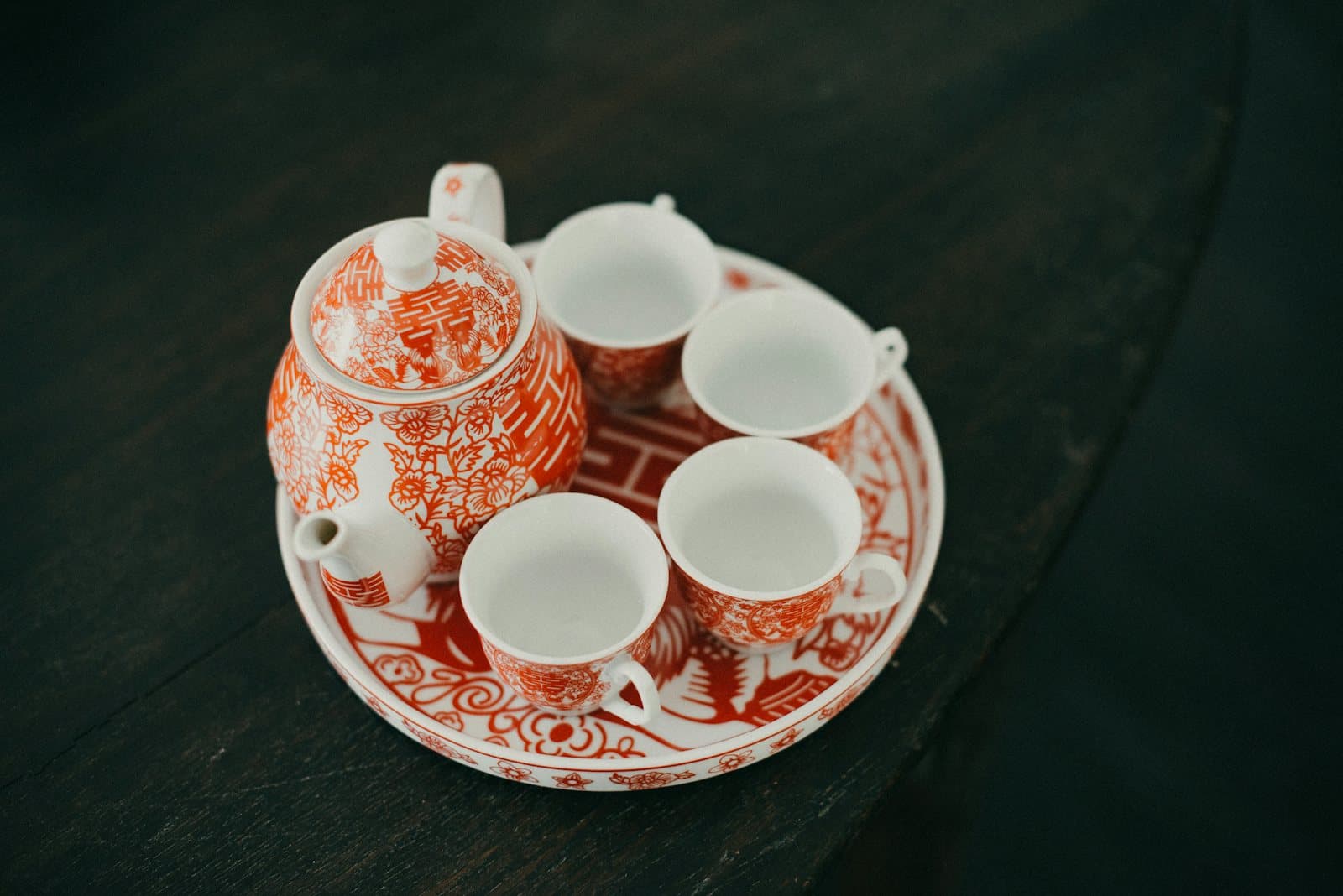 Bộ ấm chén sứ trắng hoa văn đỏ in chữ song hỷ, đặt trên khay tròn