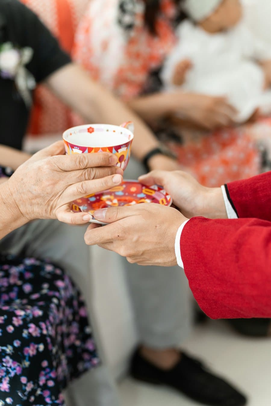 Hai bàn tay nâng chén trà mời người lớn tuổi